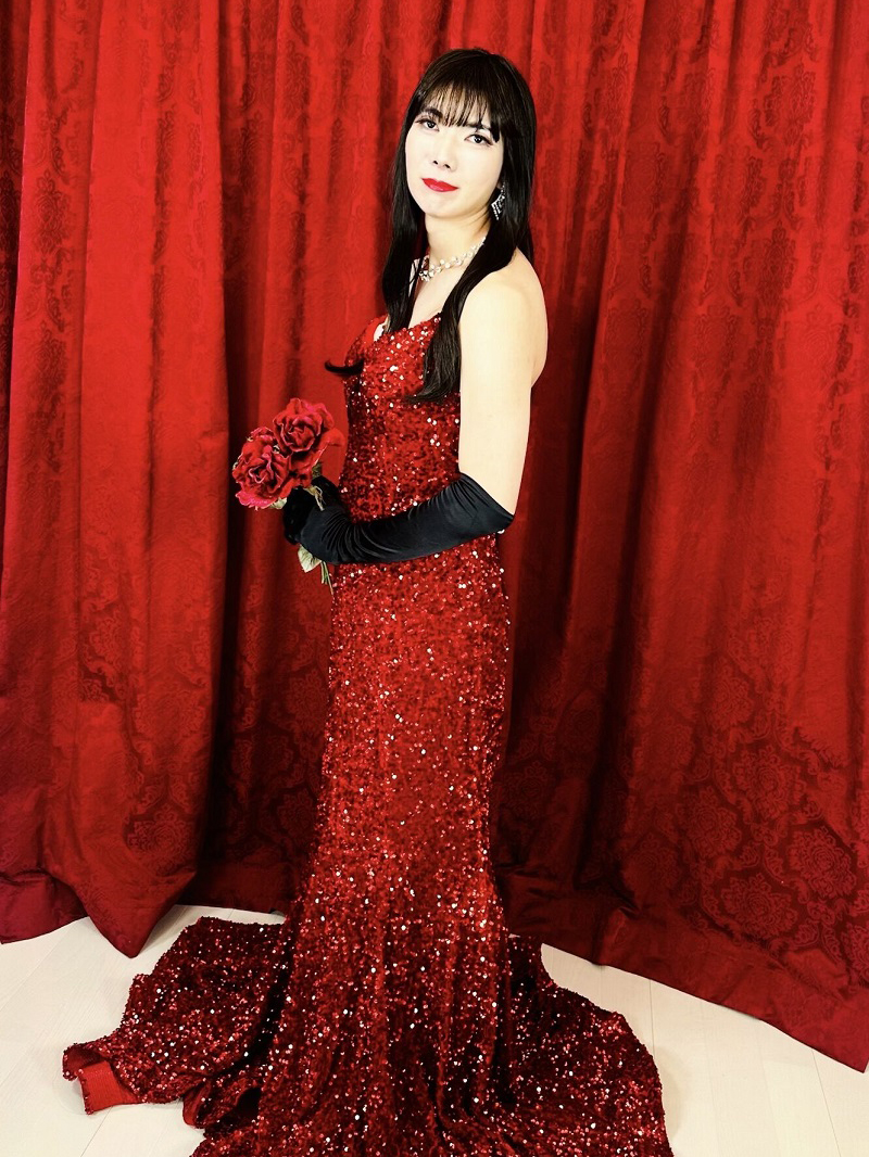 真紅ドレスのジョソンヌがバラを持ち佇む。情熱と気品を纏う女装男子の夢を叶える絶対秘密主義女装サロン「ベルマリ」。