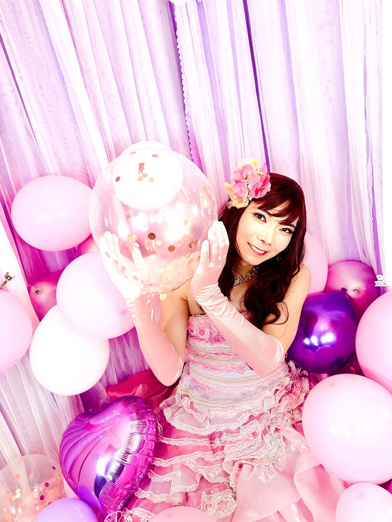 ピンクドレスとバルーンに囲まれた笑顔のジョソンヌ。「かわいい」が楽しめる秘密の女装サロン「ベルマリ」。